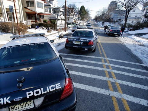 Police converge on a house in Newark, N.J., on Monday, Dec. 16, 2013, in search of suspects in the carjacking at The Mall at Short Hills on Sunday, Dec. 15, 2013. Dustin Friedland, 30, of Hoboken, N.J., was fatally shot during a carjacking at the ups