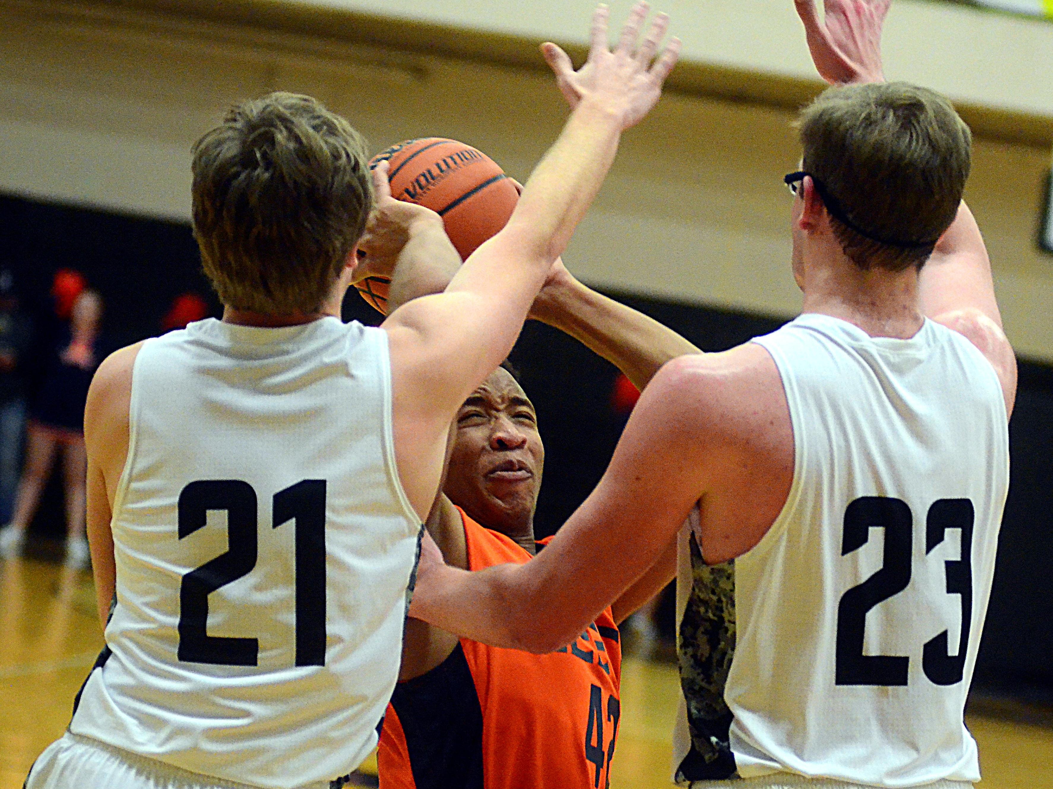 Beech High senior Caleb Walton is surrounded by Hendersonville junior Justin Ernst (21) and senior Preston Brown during second-quarter action. Walton scored 11 points.