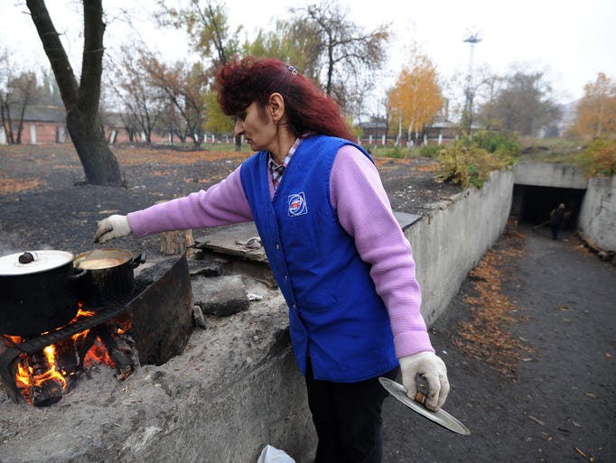 Between shellings a woman cooks on Oct. 23, outside