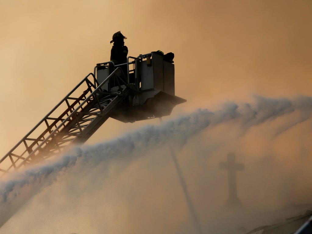 Chicago firefighters work at the scene of an extra-alarm fire at Shrine of Christ the King Church in Chicago. About 150 firefighters responded when flames engulfed the 92-year-old church on Chicago's South Side.