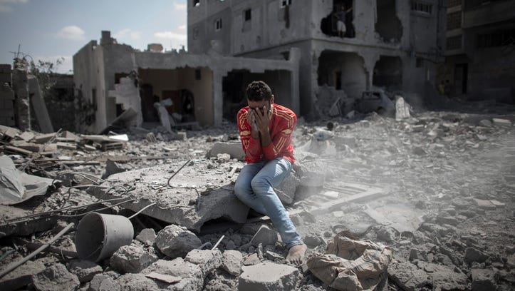A Palestinian man cries in front of his destroyed house in Beit Hanoun, northern Gaza Strip, on July 26, 2014.