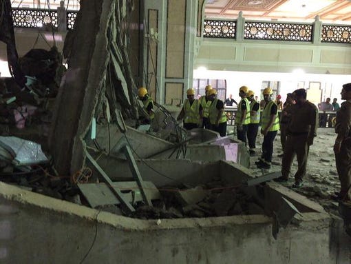 Civil defense workers examine the remains of a crane