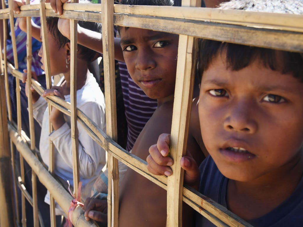 Rohingya refugees look through a temporary bamboo barricade at the Thankhali refugee camp in Bangladesh's Ukhia district.