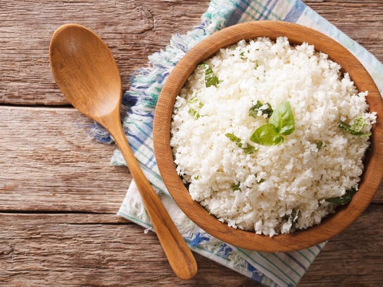 Cauliflower rice with basil in bowl close-up. Horizontal top view