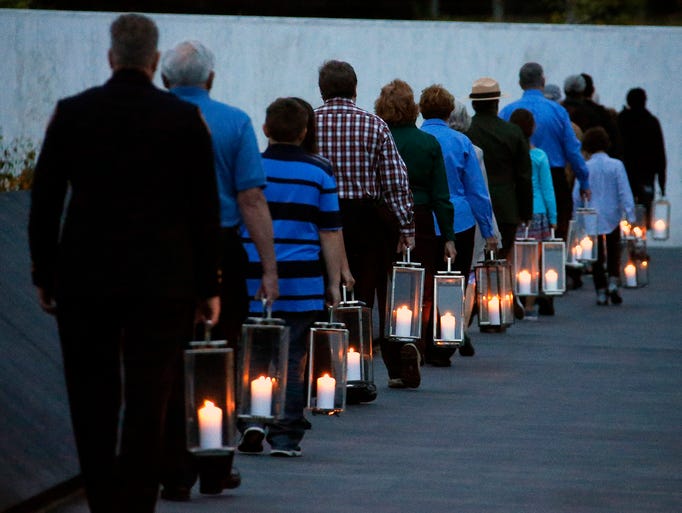 Candles to commemorate the 40 passengers and crew on United Airlines Flight 93 are carried to the Wall of Names at the Flight 93 National Memorial.