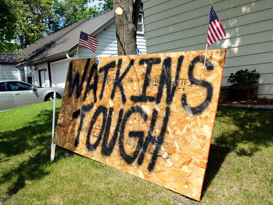 A sign reads, "WATKINS TOUGH" is proudly propped outside