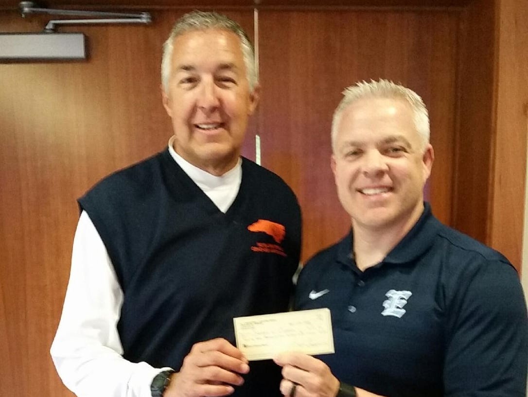 Enka boys basketball coach Brian Carver, right, presents a check to N.C. Basketball Coaches Association treasurer Gary Bowne from last year's Coaches vs. Cancer Shootout in Asheville.