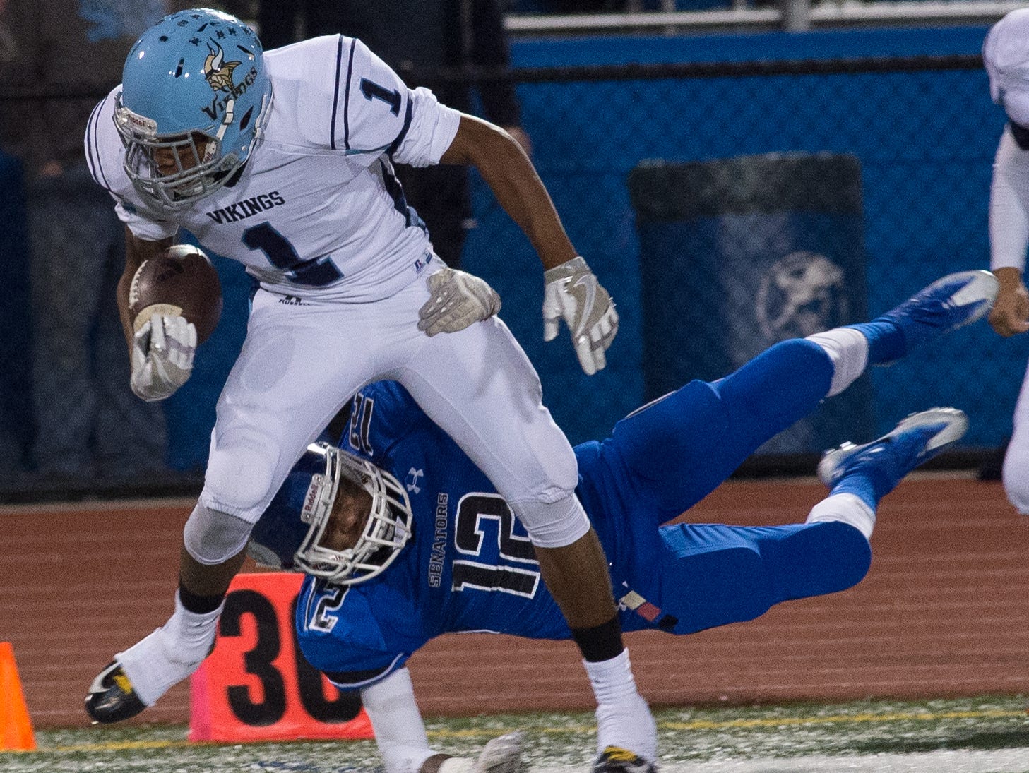 Dover's Jarvis Worthy (12) tackles Cape Henlopen's Jerry Harden (1) at the 30 yard line.