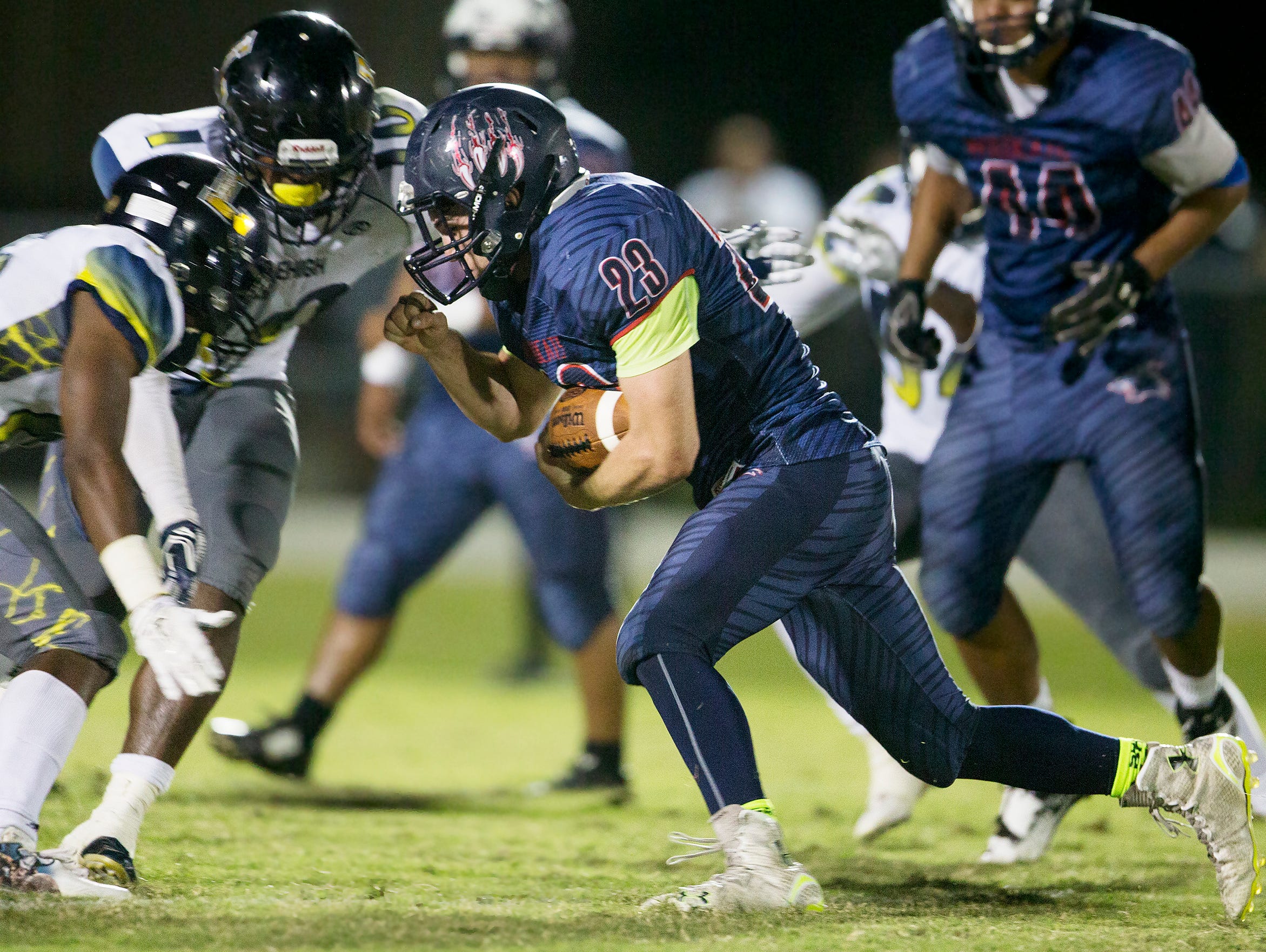 Estero High School’s Jonathan Rauss takes on Lehigh defenders during second quarter play on Friday at Estero High School.