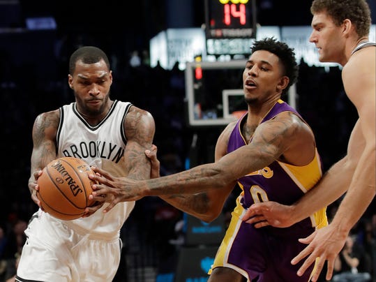 Brooklyn Nets' Sean Kilpatrick, left, drives past Los Angeles Lakers' Nick Young, center, as teammate Brook Lopez, right, watches during the second half of an NBA basketball game Wednesday, Dec. 14, 2016, in New York. The Nets won 107-97. (AP Photo/Frank Franklin II)