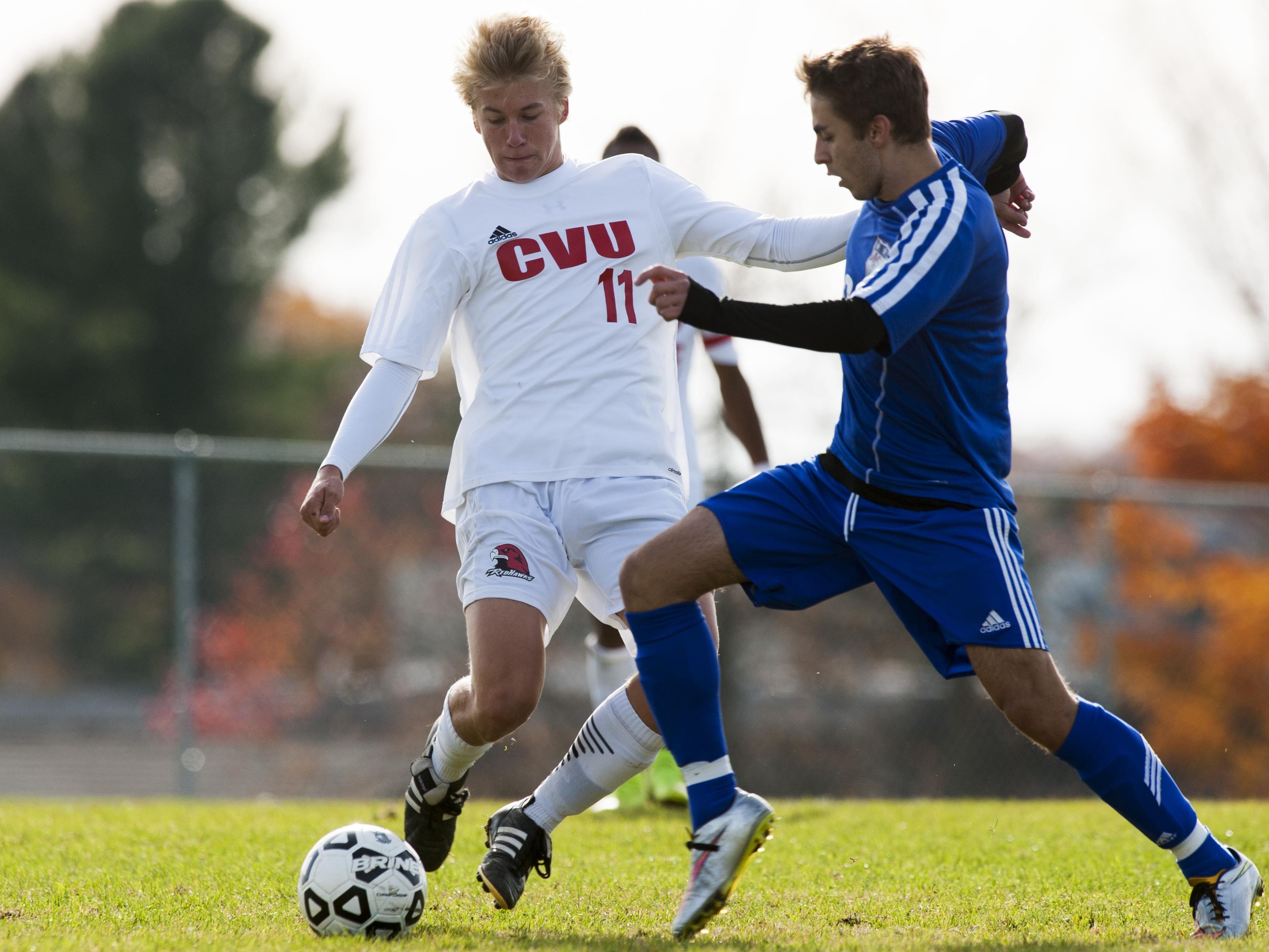 Mount Anthony’s Trey Lang (8) battles for the ball with CVU’s Kyler White-Hansen (11) during the Division I boys soccer semifinal game.