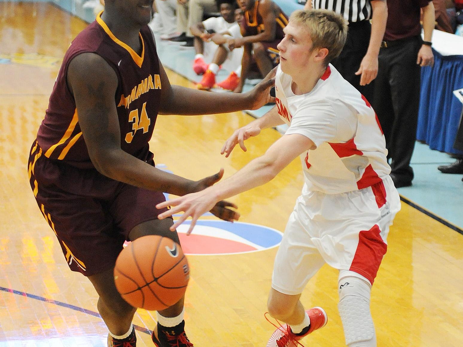 Smyrna's #10 Caleb Matthews pass's the ball around Bishop McNamara's Makhel Mitchell as The Annual Slam Dunk to the Beach Basketball Tournament started at Cape Henlopen High School in Lewes on Tuesday December 27th with Smyrna HS (white) hosting Bishop McNamara HS from Forestville, Md.