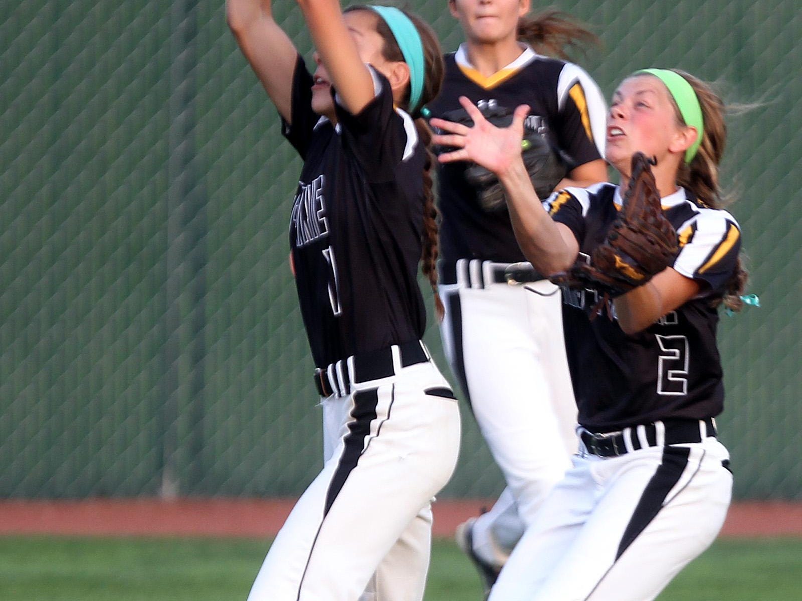 Mid-Prairie's Alex Rath avoids Lexi Duwa and catches the ball in centerfield during their regional game against Mid-Prairie at Solon on Friday, July 10, 2015. David Scrivner / Iowa City Press-Citizen