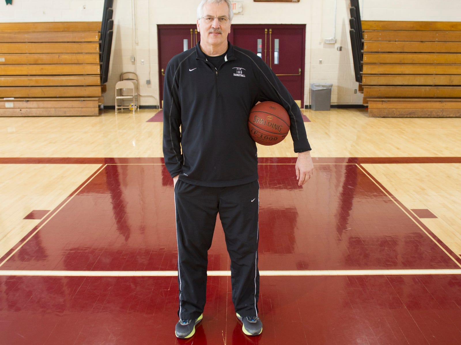 Iowa Mennonite School head coach Dwight Gingerich poses in his school's gym on Wednesday, Feb. 11, 2015.