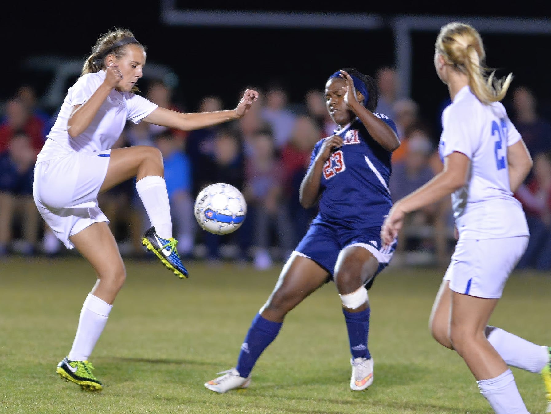 White House High freshman defender Allyson Trimmer plays a ball out of the air in front of White House Heritage senior Faith Williamson.