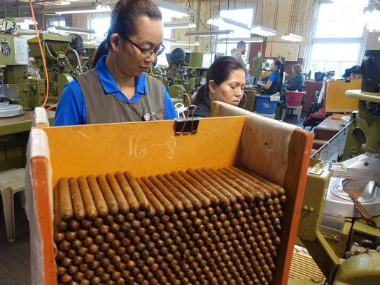 Workers at the at J.C. Newman cigar factory, using
