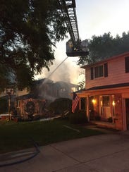 Firefighters battle a house fire that destroyed a two-story