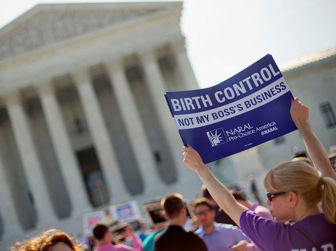 A demonstrator in favor of birth control coverage protests outside the Supreme Court in Washington.