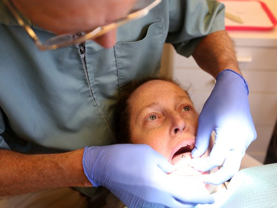 Vickie Adams, 41, of Salem, is fitted for bottom dentures