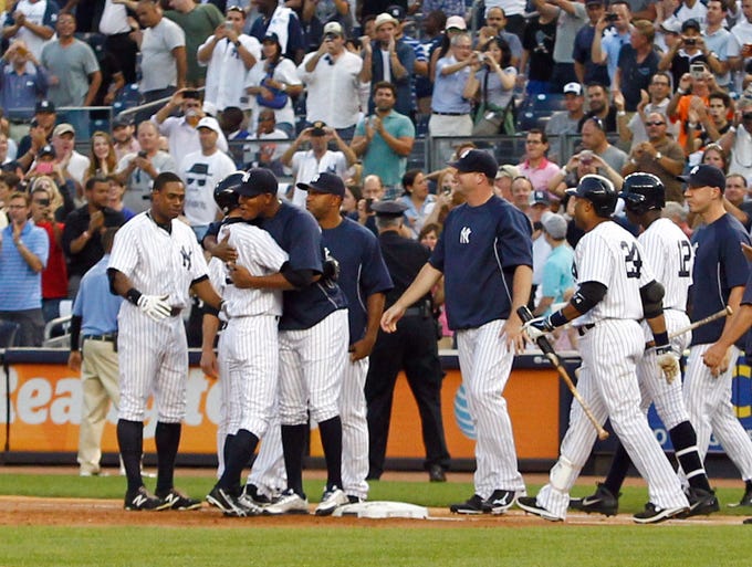New York Yankees right fielder Ichiro Suzuki  is congratulated by teammates after recording his 4000th hit against the Toronto Blue Jays at Yankee Stadium.