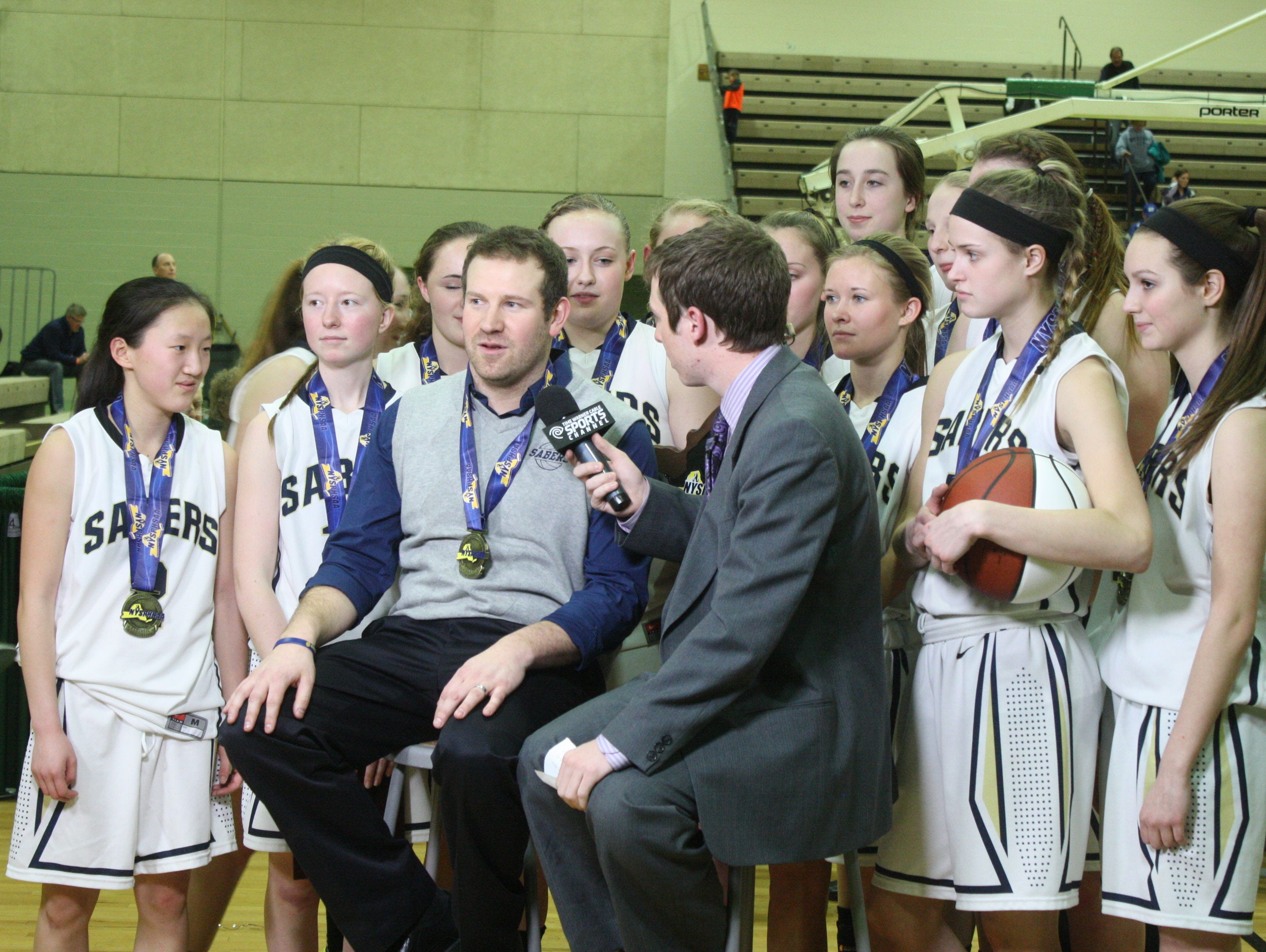 Susquehanna Valley girls basketball coach Chad Freije is interviewed following the Sabers’ 51-45 victory over Hoosick Falls in the state Class B championship game March 21 at Hudson Valley Community College in Troy.
