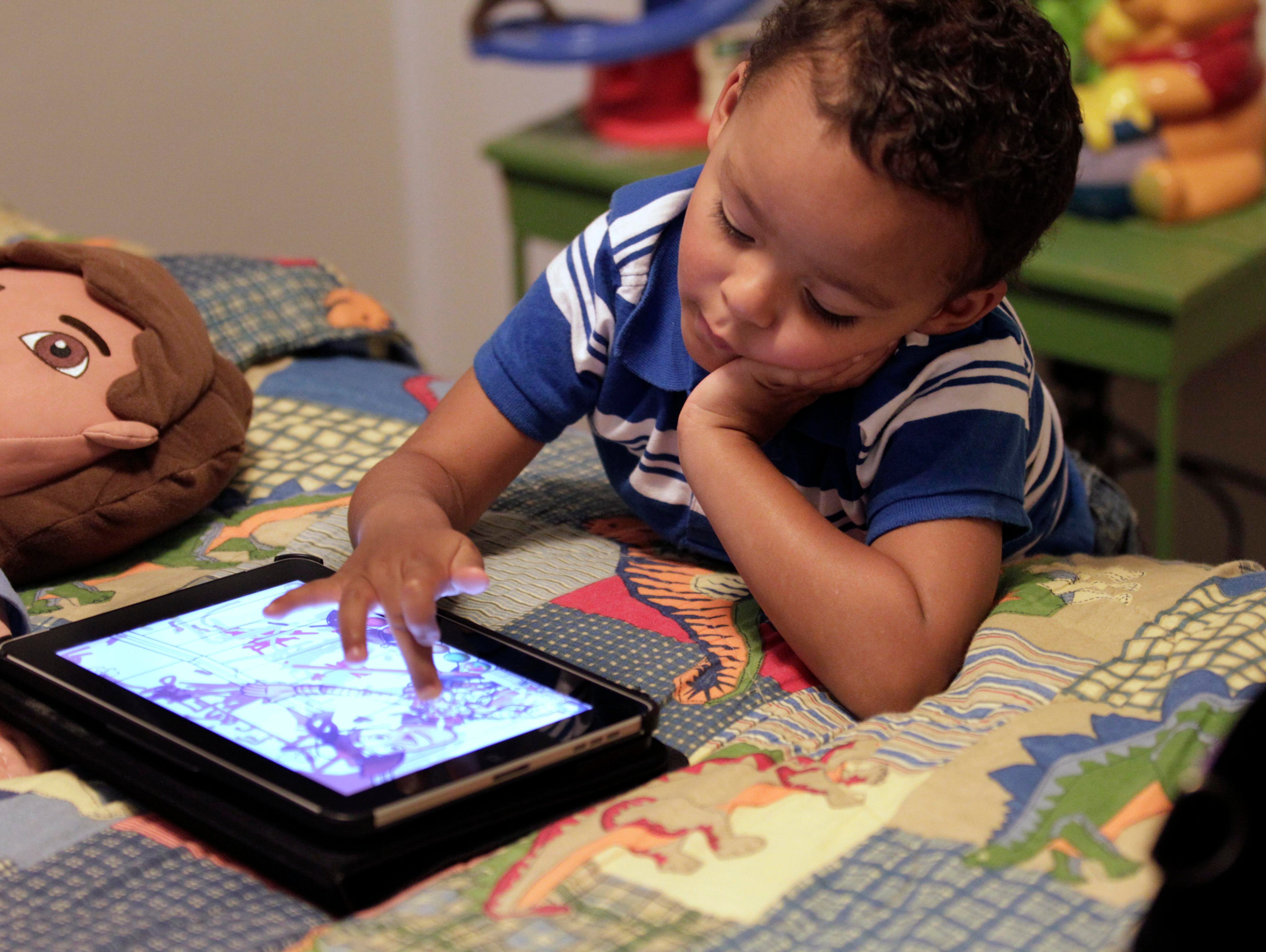 Frankie Thevenot, then 3, plays with an iPad in his bedroom at his home in Metairie, La., in 2011.