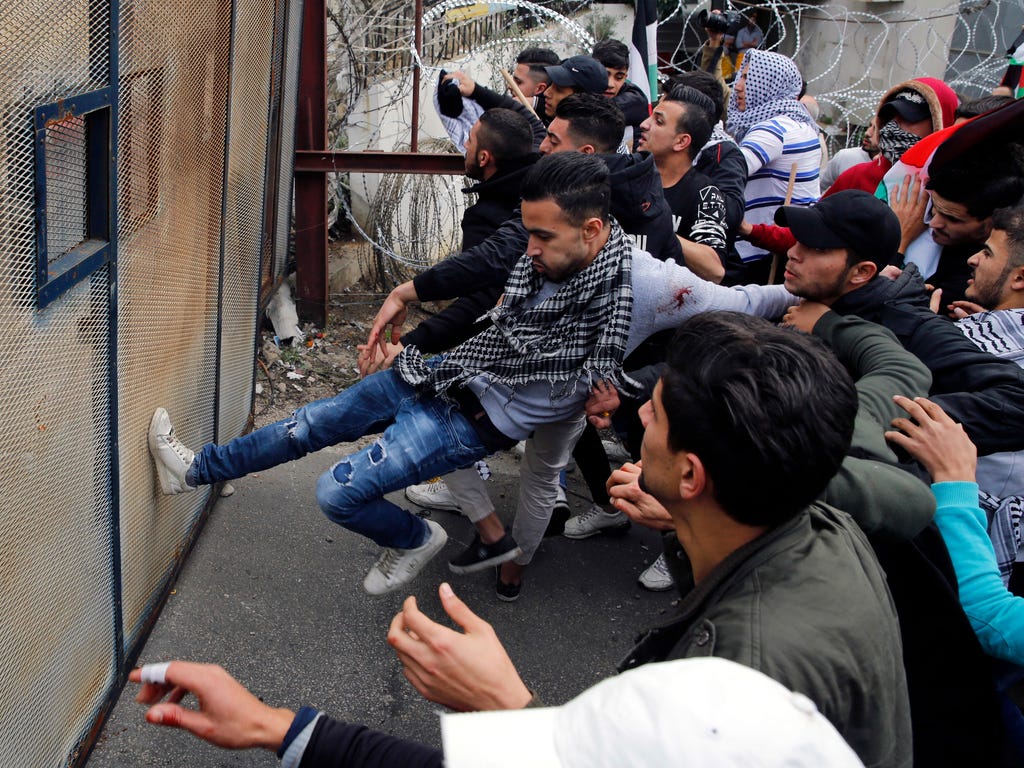 Protesters try to enter the U.S. Embassy during a demonstration in Aukar, east of Beirut, Lebanon, Dec. 10, 2017. Scores of demonstrators, including Palestinians, pelted security outside the embassy with stones and burned an effigy of President Trump