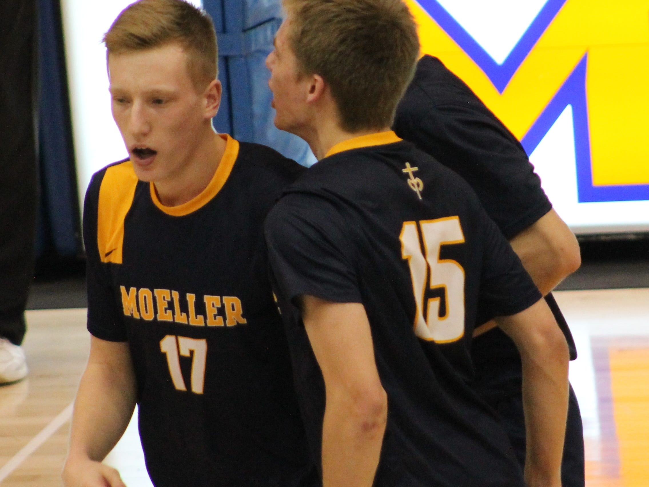 Moeller’s Connor McNamara (17) and David Wernery (15) celebrate after a Crusader point against Beavercreek March 31. Both are juniors.
