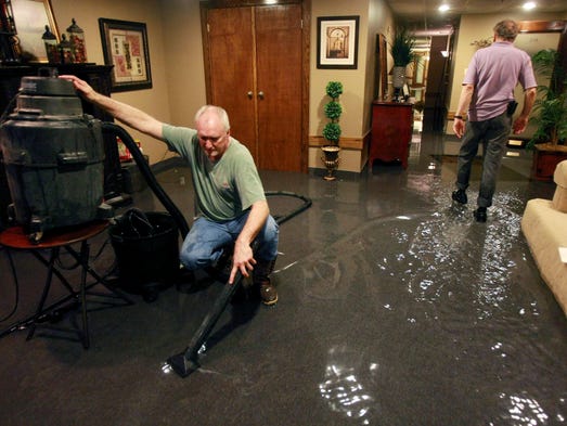 T. W. Hale, left, helps his friends by vacuuming water