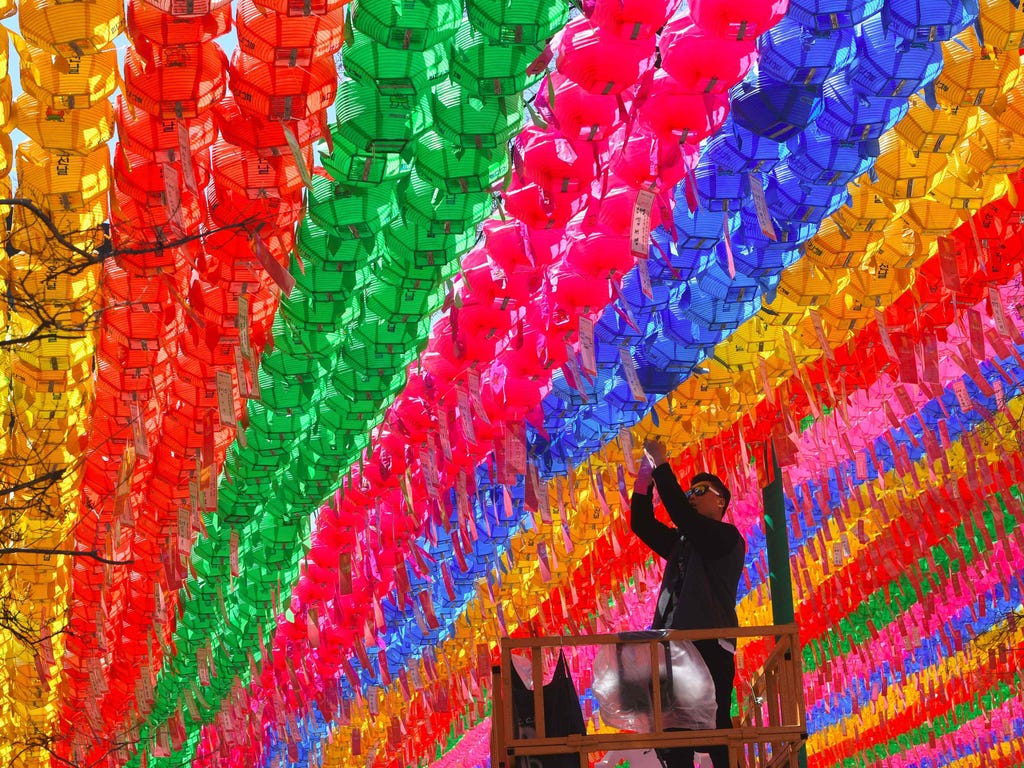 A South Korean worker attaches a name card with a wish of Buddhist followers to a lotus lantern at Jogye Temple in Seoul  ahead of celebrations marking Buddha's birthday in the country.