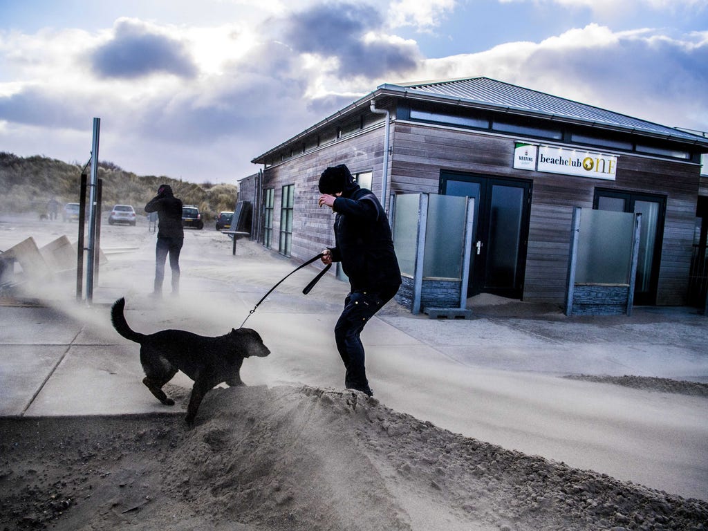 People walking in the strong winds on the beach of Hoek van Holland, The Netherlands during the second western storm of the year.