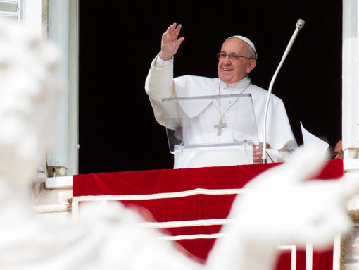 Pope Francis waves to people from his studio window