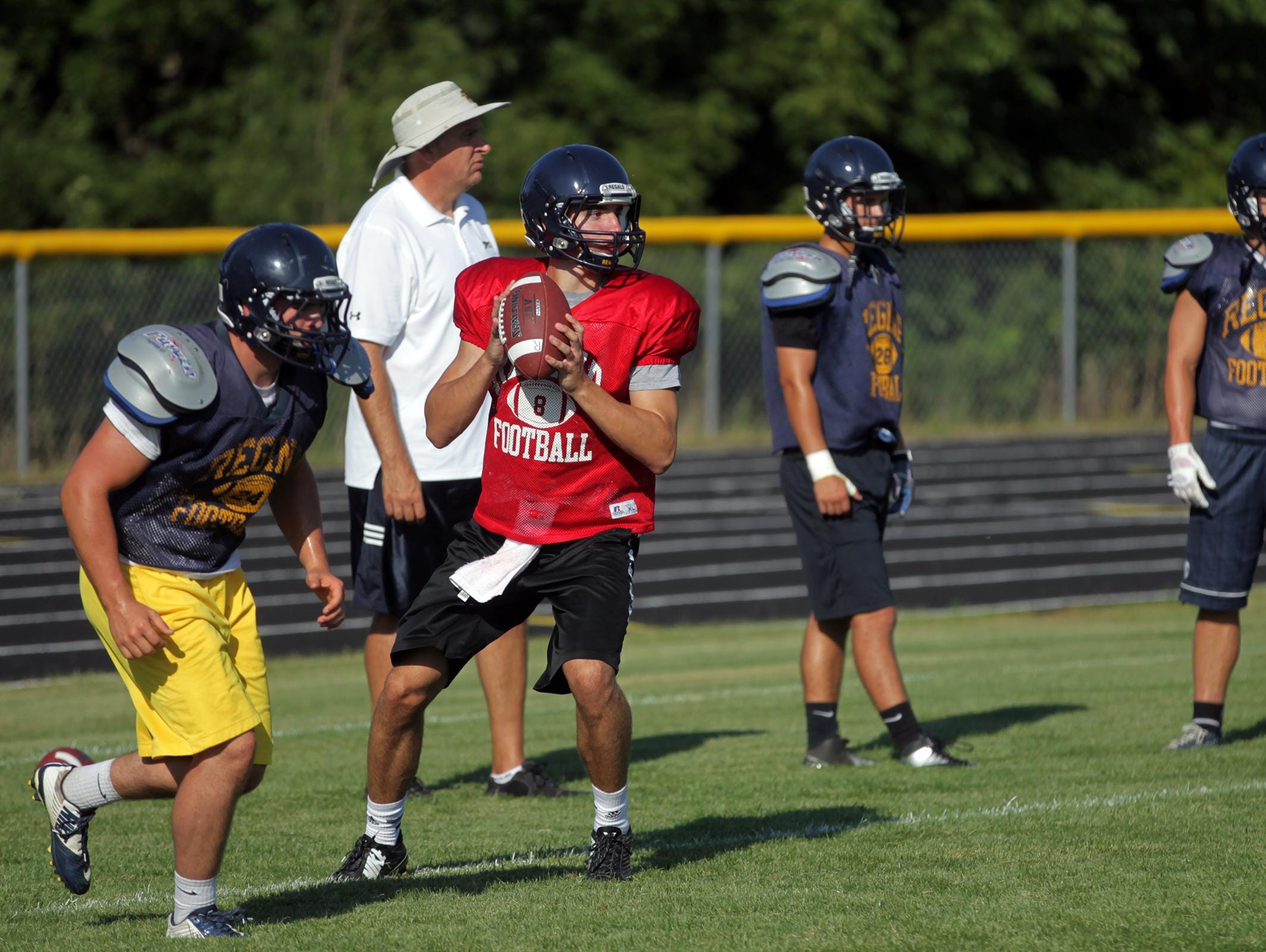 Regina quarterback Nathan Stenger looks for a receiver during practice on Wednesday, Aug. 12, 2015.