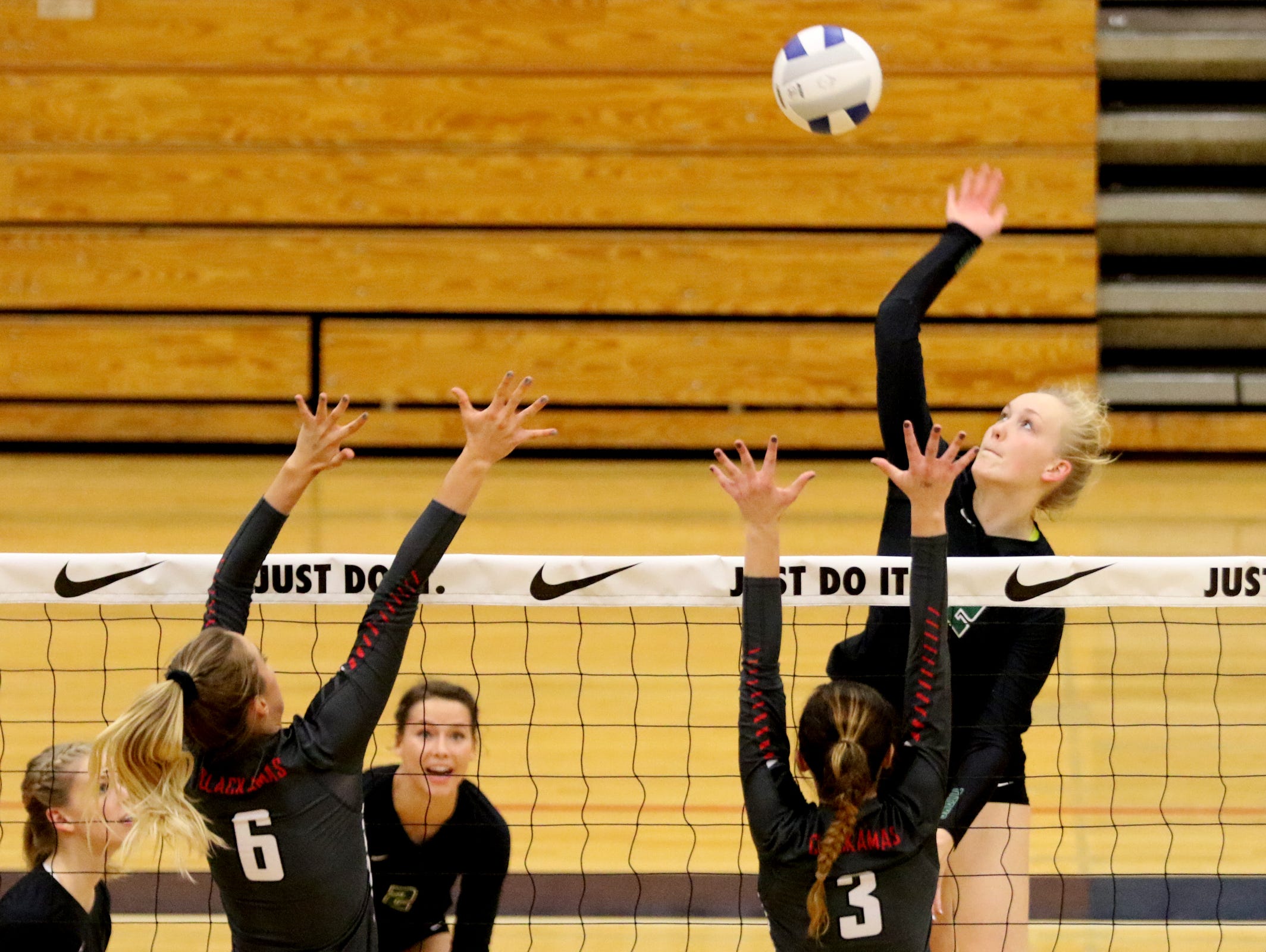 West Salem's Paige Whipple (12) spikes the ball past Clackamas' Calla Meyer (6) and Kayley Andersen (3) in the OSAA Class 6A quarterfinal volleyball match of Clackamas vs. West Salem at Liberty High School in Hillsboro on Friday, Nov. 4, 2016. West Salem lost in four sets.