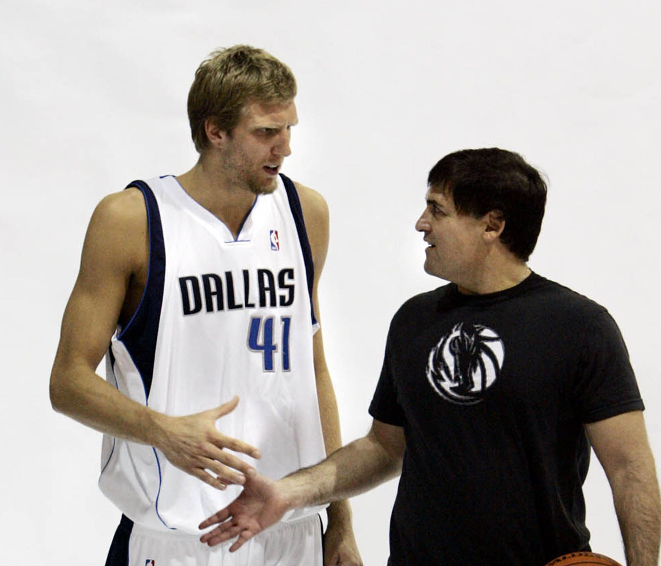 Dallas Mavericks Dirk Nowitzki, left, of Germany, and team owner Mark Cuban shake hands after posing for the team photographer during media day in Dallas, Monday, Oct. 2, 2006. (AP Photo/LM Otero) ORG XMIT: TXLM104