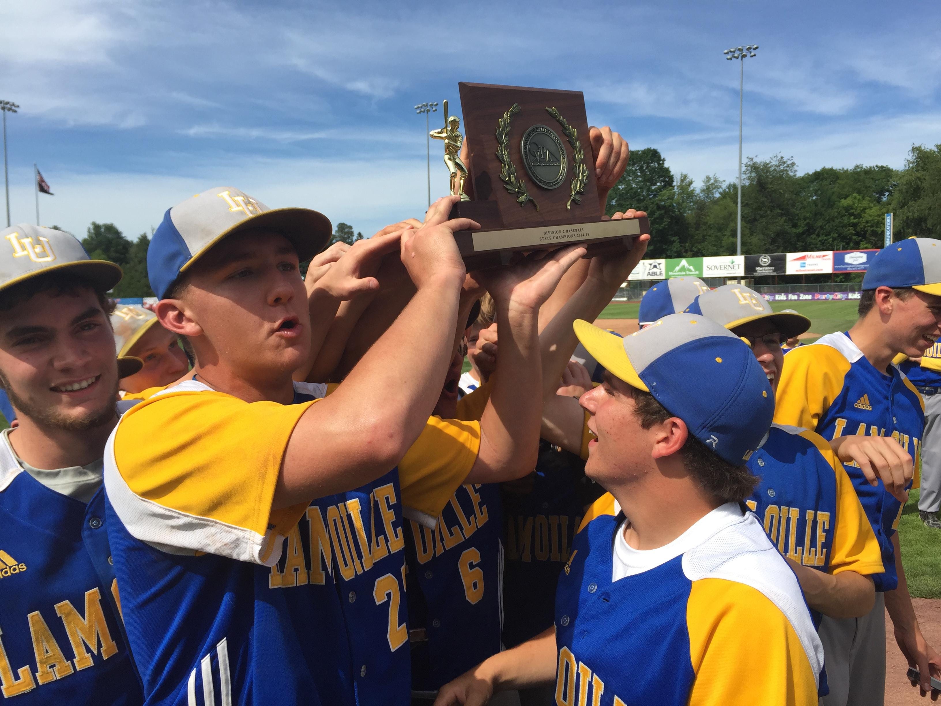 The Lamoille baseball team lifts the trophy after winning the Division II state championship.