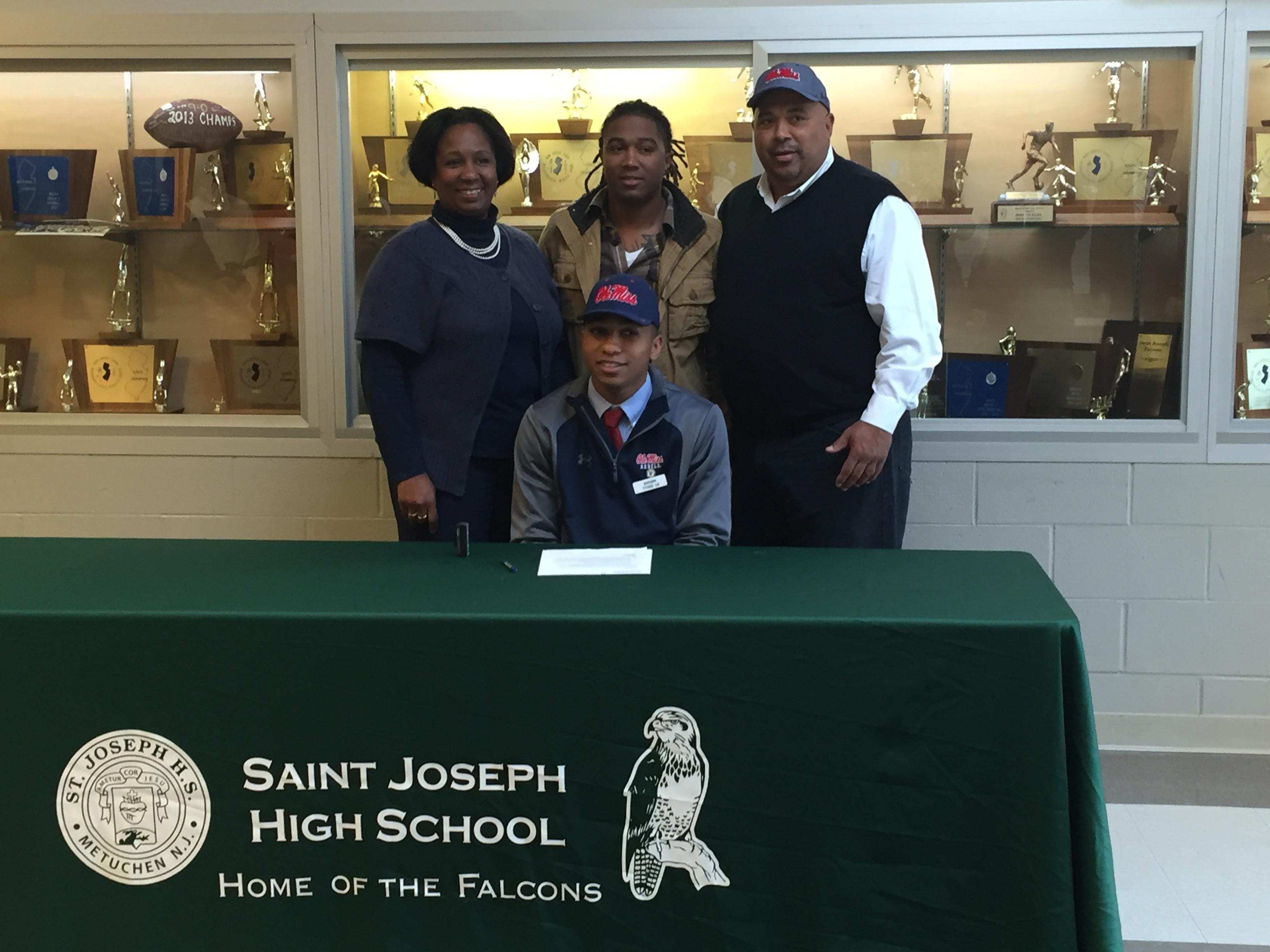 St. Joseph’s Breein Tyree signs his National Letter of Intent to play basketball for the University of Mississippi surrounded by his family on Wednesday.