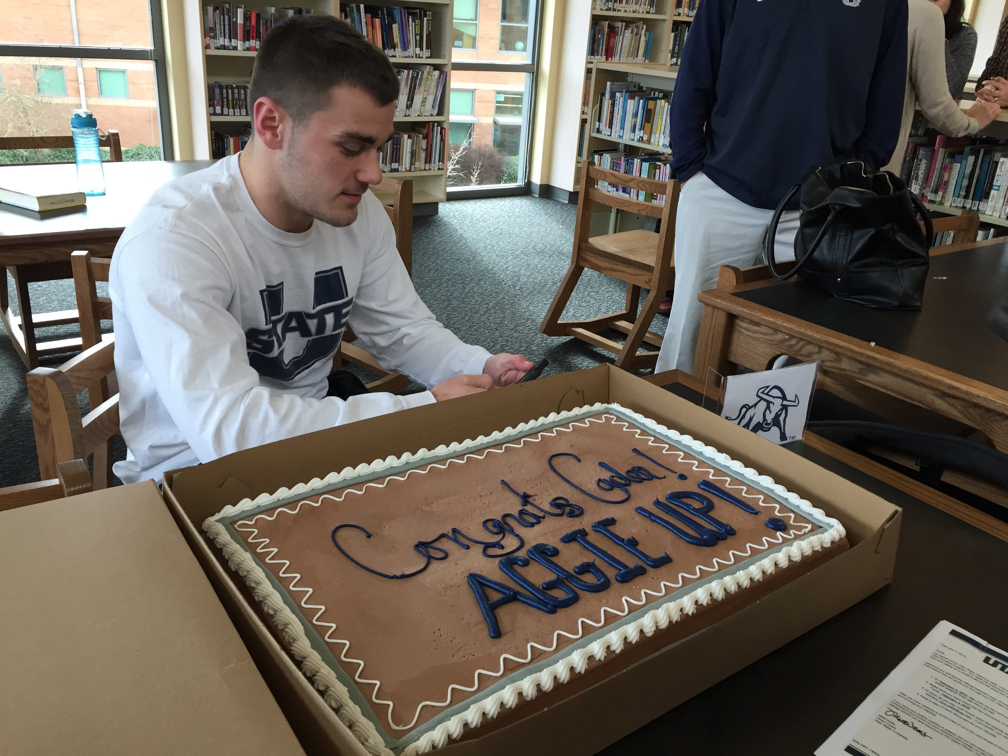 Cade Smith sits with his cake at his signing ceremony on Wednesday, Feb. 4, 2015.