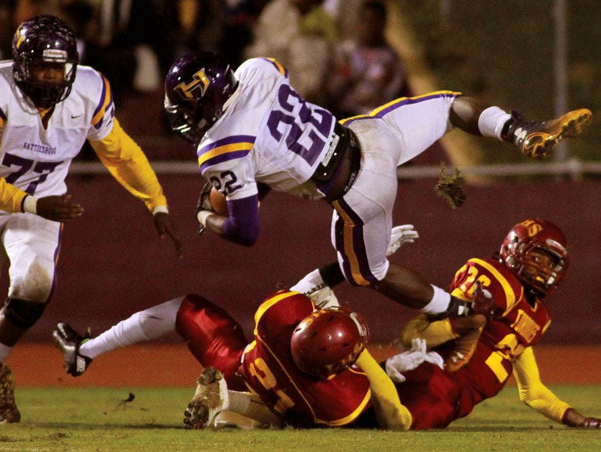 Hattiesburg running back Fabian Franklin dives for a few extra yards over Laurel defenders Shiwon Lovett (20) and Daveon Rogers (21) during playoff action Friday at Laurel.