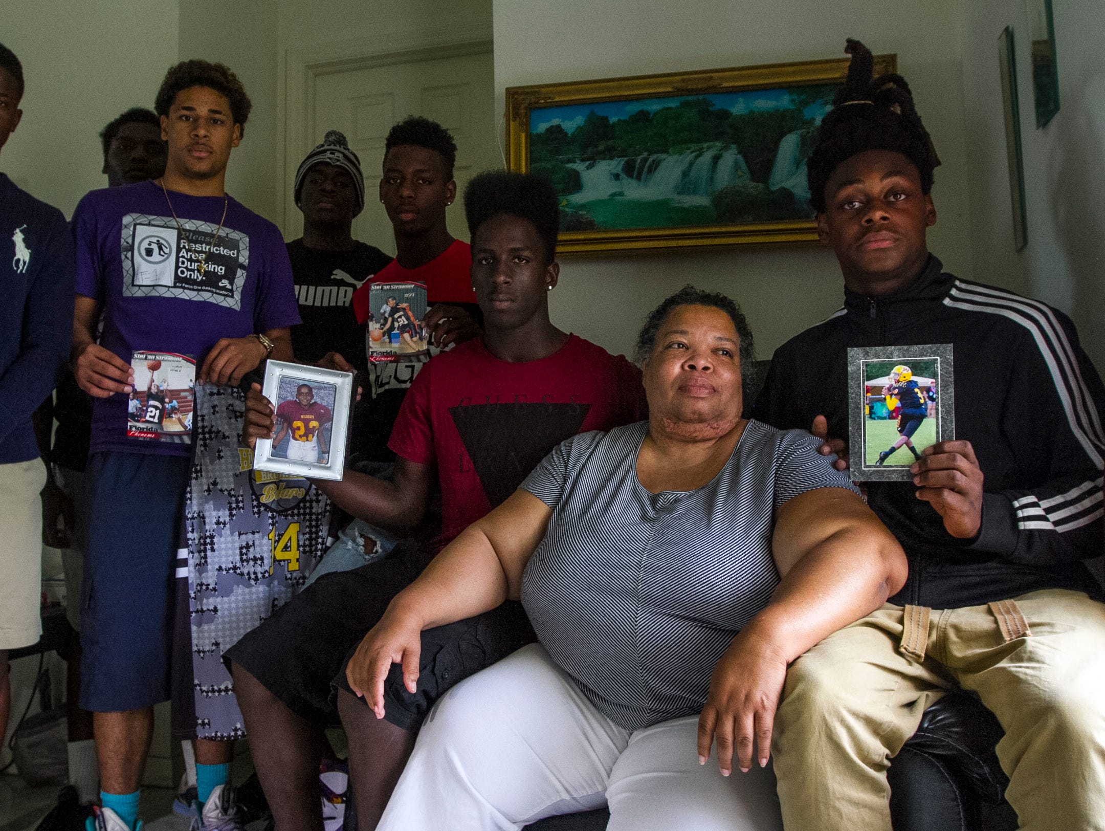 Stephanie White, Stef'An Strawder's mother, is surrounded by her son's friends and teammates Monday afternoon at her home in Lehigh Acres. Her son's friends and teammates were visiting to provide her with support as she grieved her son's loss earlier that day during a shooting in Fort Myers.