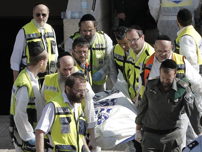 Israeli emergency services members carry a body at