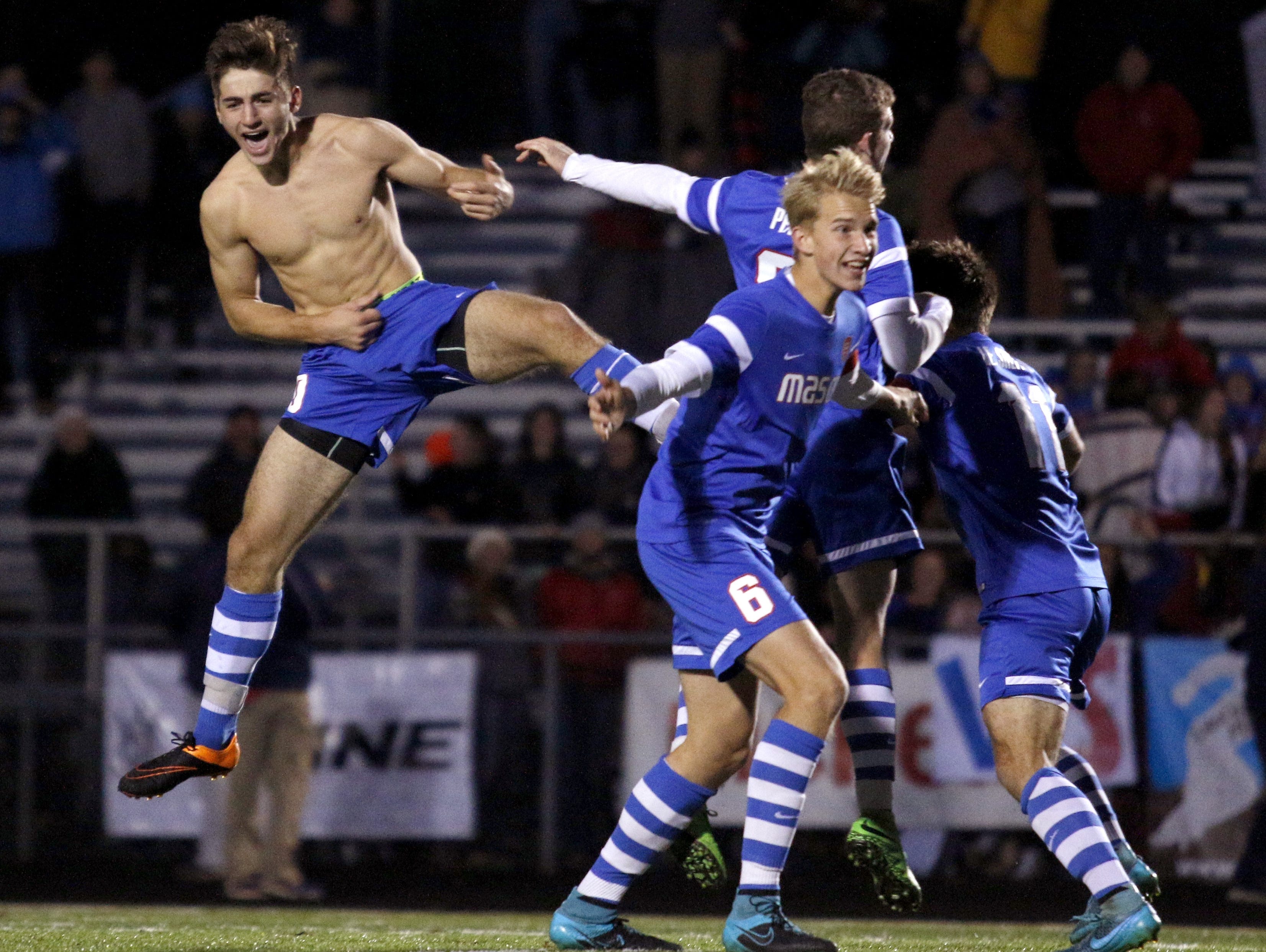 Mason's Lirim Shefkiu, left, Holden Dippel (6), Tristan Pease and Leutrim Shefkiu, right, celebrate after Lirim Shefkiu kicked a game-winning shootout goal against Grand Rapids Forest Hills Northern last year to win the Division 2 state soccer championship. Lirim Shefkiu is one of just two returning starters from that team.