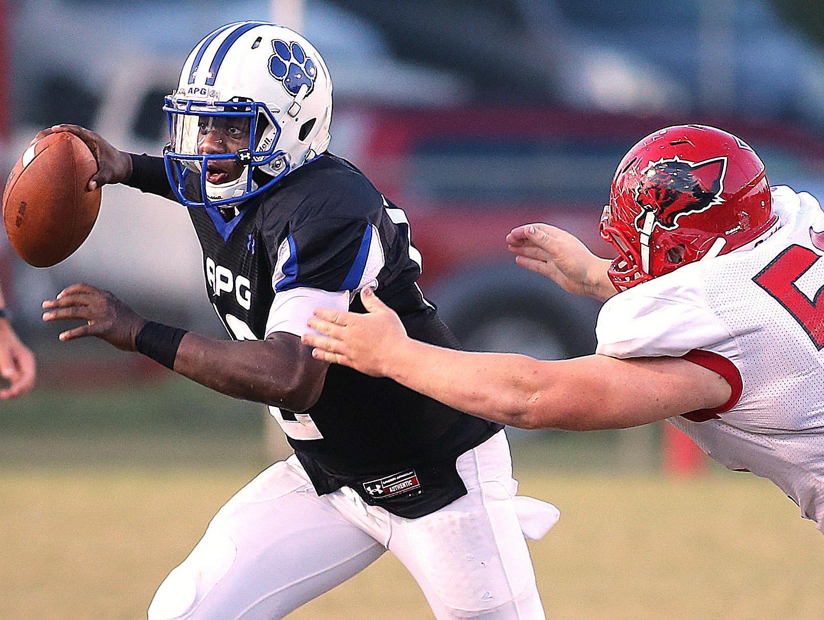 Former Godby quarterback J.T. Bradwell tries to escape the grasp of current Leon senior Gabe Beyer during a September 2013 game. The Cougars have won the last four meetings against Leon by an average score of 50-8.