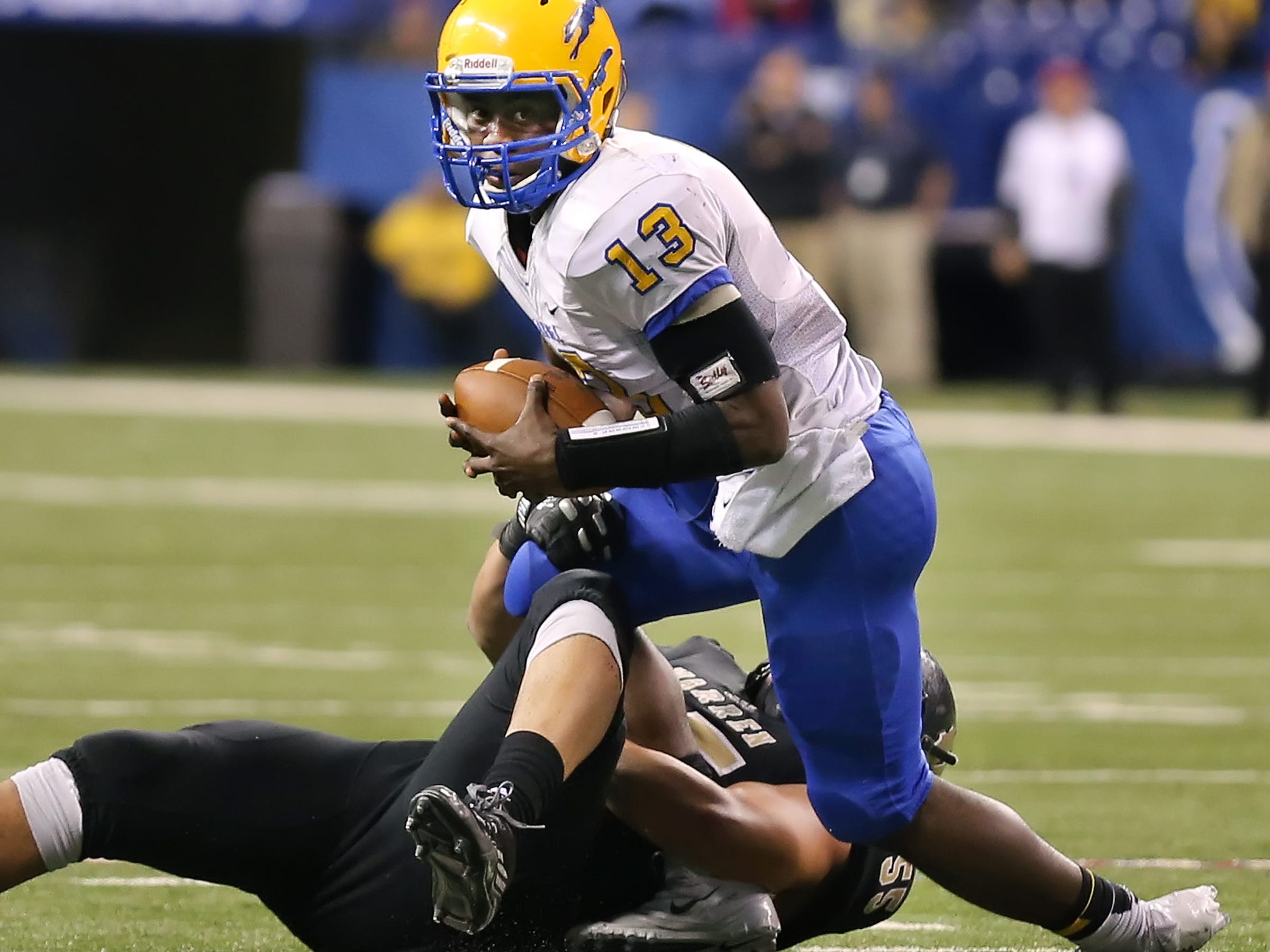 Carmel quarterback Isaac James is sacked for a loss by Warren Central defensive lineman Max Hernandez in the second half of the IHSAA Class 6A State Football Finals held at Lucas Oil Stadium on Saturday, November 30, 2013. Warren Central beat Carmel 7-6.