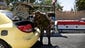 A Syrian soldier searches the trunk of a car at a checkpoint in Damascus.