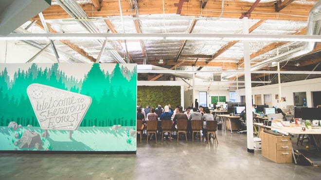 Robinhood to resume activity on GameStop, AMC 2 Robinhood headquarters with people seated around a conference table in the background.