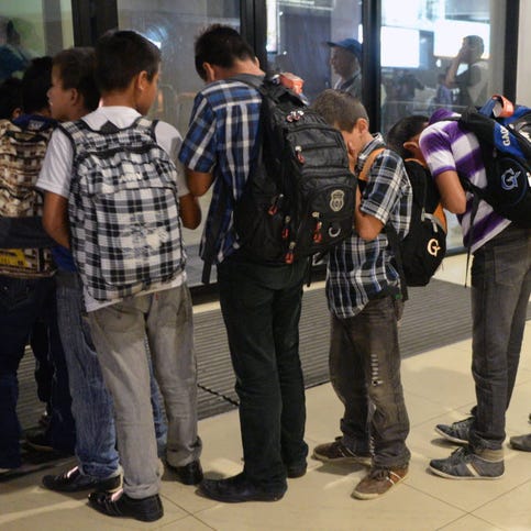 Part of a group of 16 Guatemalan children caught in Mexico while trying to migrate illegally into the United States, queue before climbing into a minibus at Aurora international airport in Guatemala City.