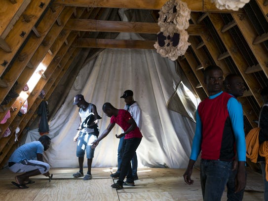 Haitian migrants help build an addition to the Desayunador
