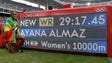 Almaz Ayana of Ethiopia poses with the scoreboard after