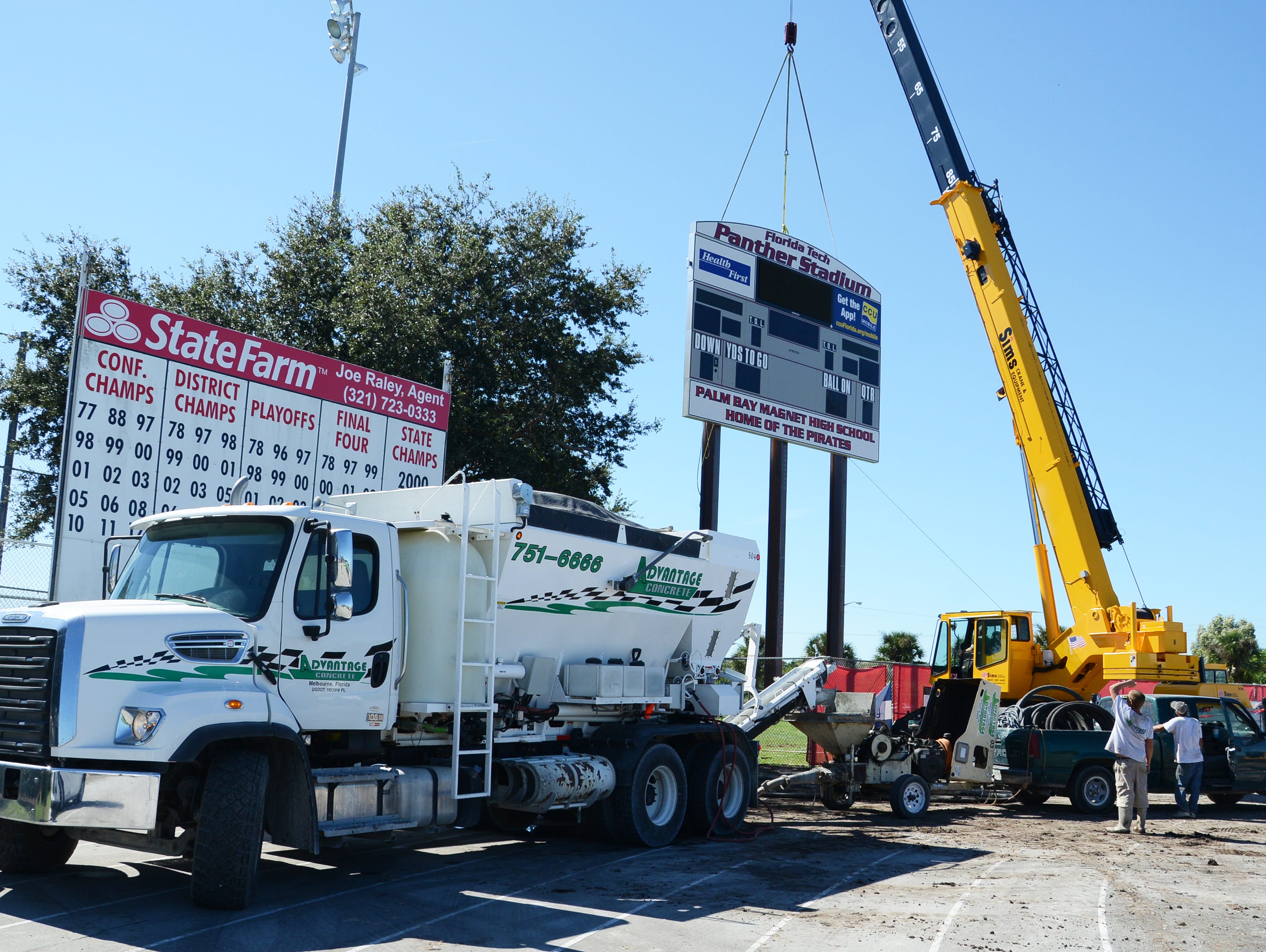 Workers install the new scoreboard sign at Panther Stadium in Melbourne Friday.